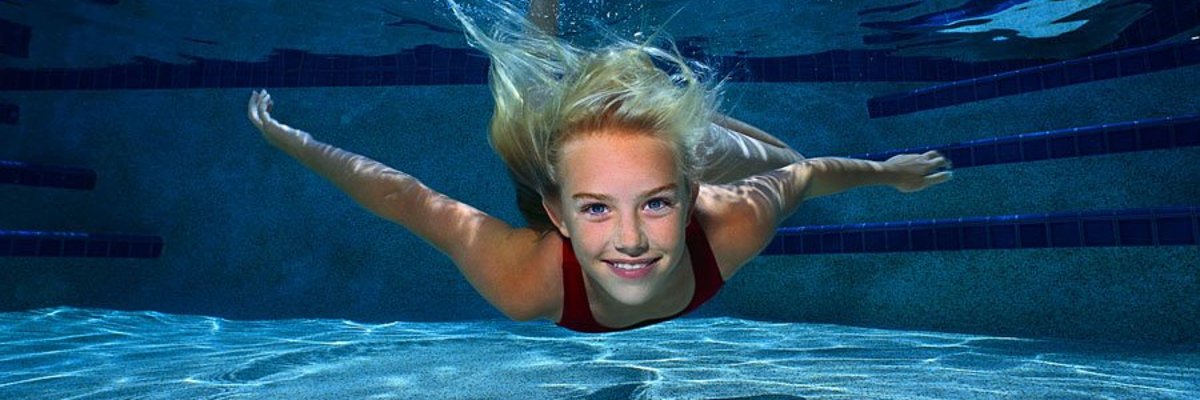 Junges Maedchen schwimmt unterwasser
