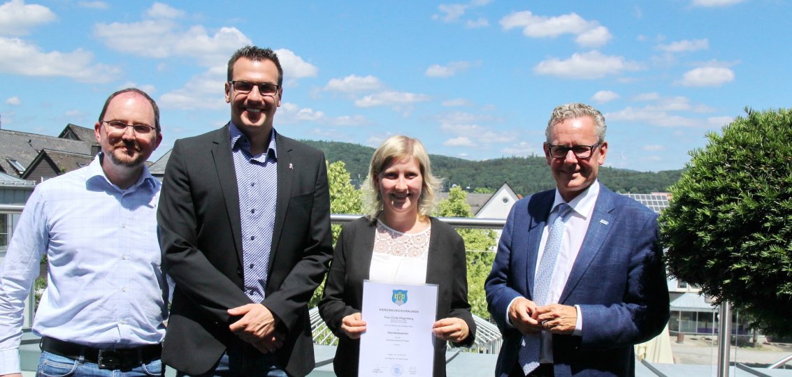 Foto von Ciny Hilgenberg mit Urkunde sowie Bürgemeister Mario Schramm, Jochen Schüler und Timo Dietermann